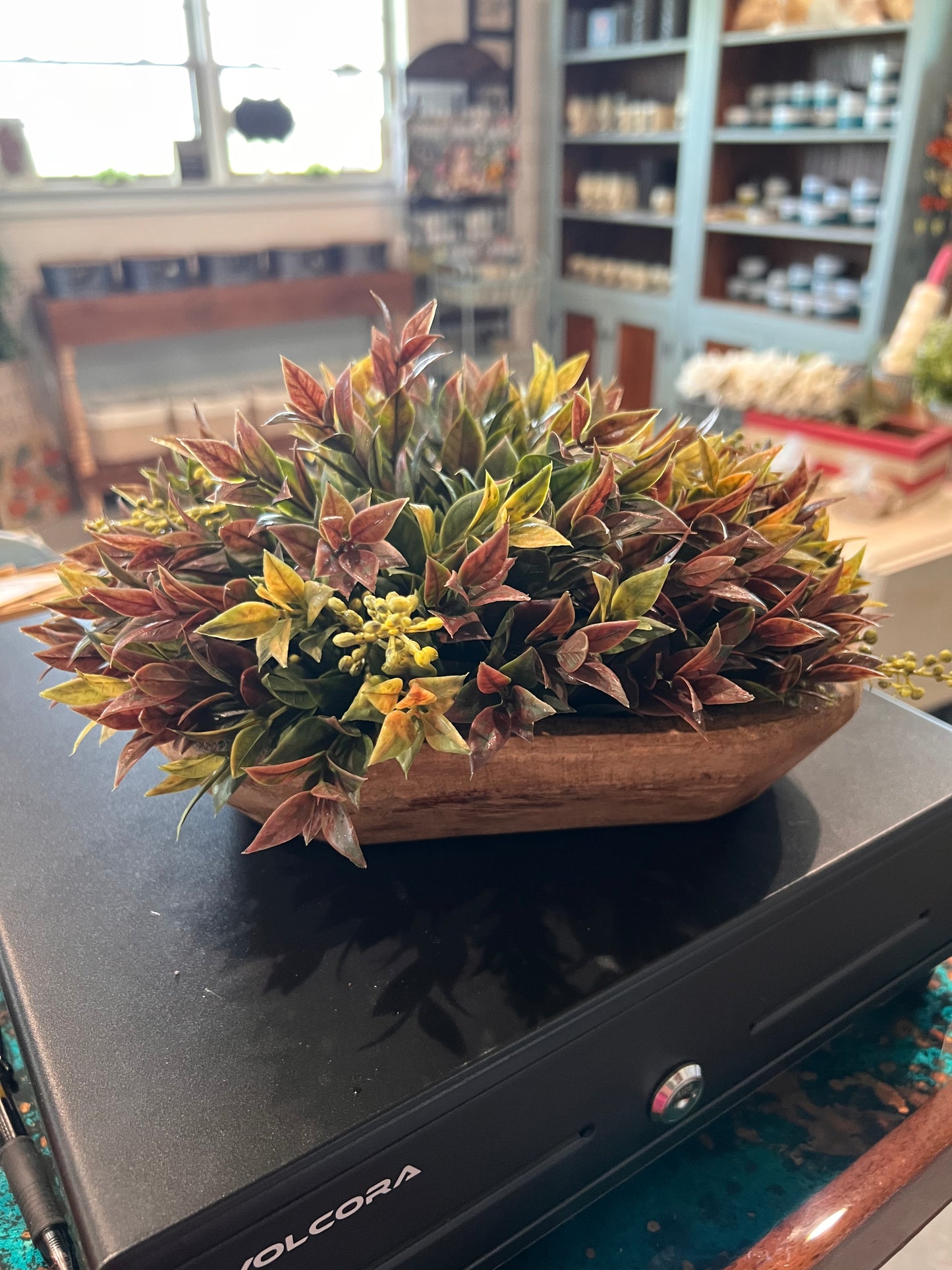 Dusty Laurel half sphere in rich shades of autumn colors displayed in a dough bowl.