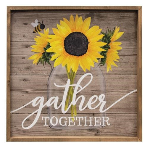 Decorative sign with sunflowers and 'gather together' text on a wooden background