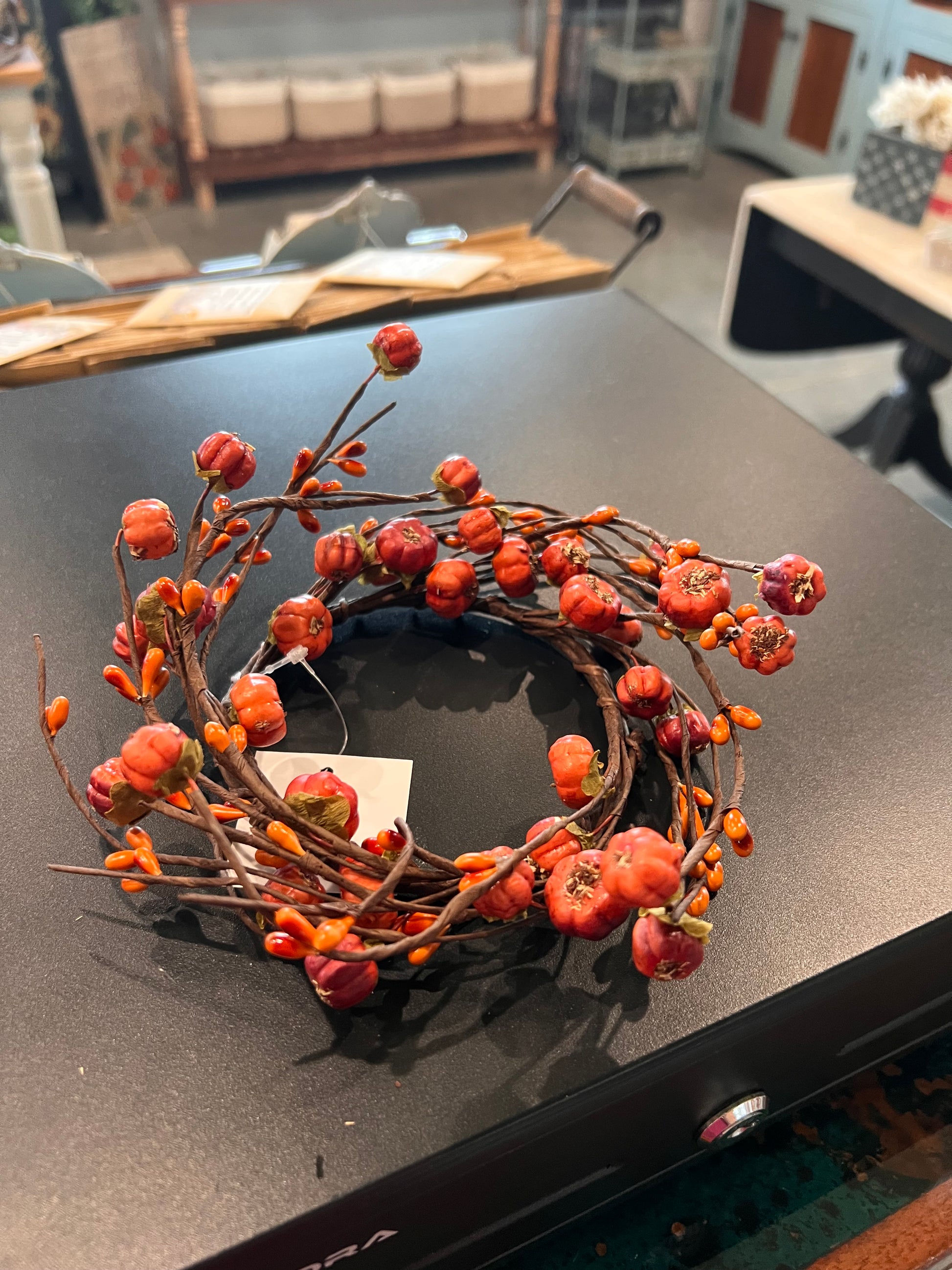 Twisting brown vines are filled with warm orange pip berries and petite pumpkin-like pods in shades of orange.