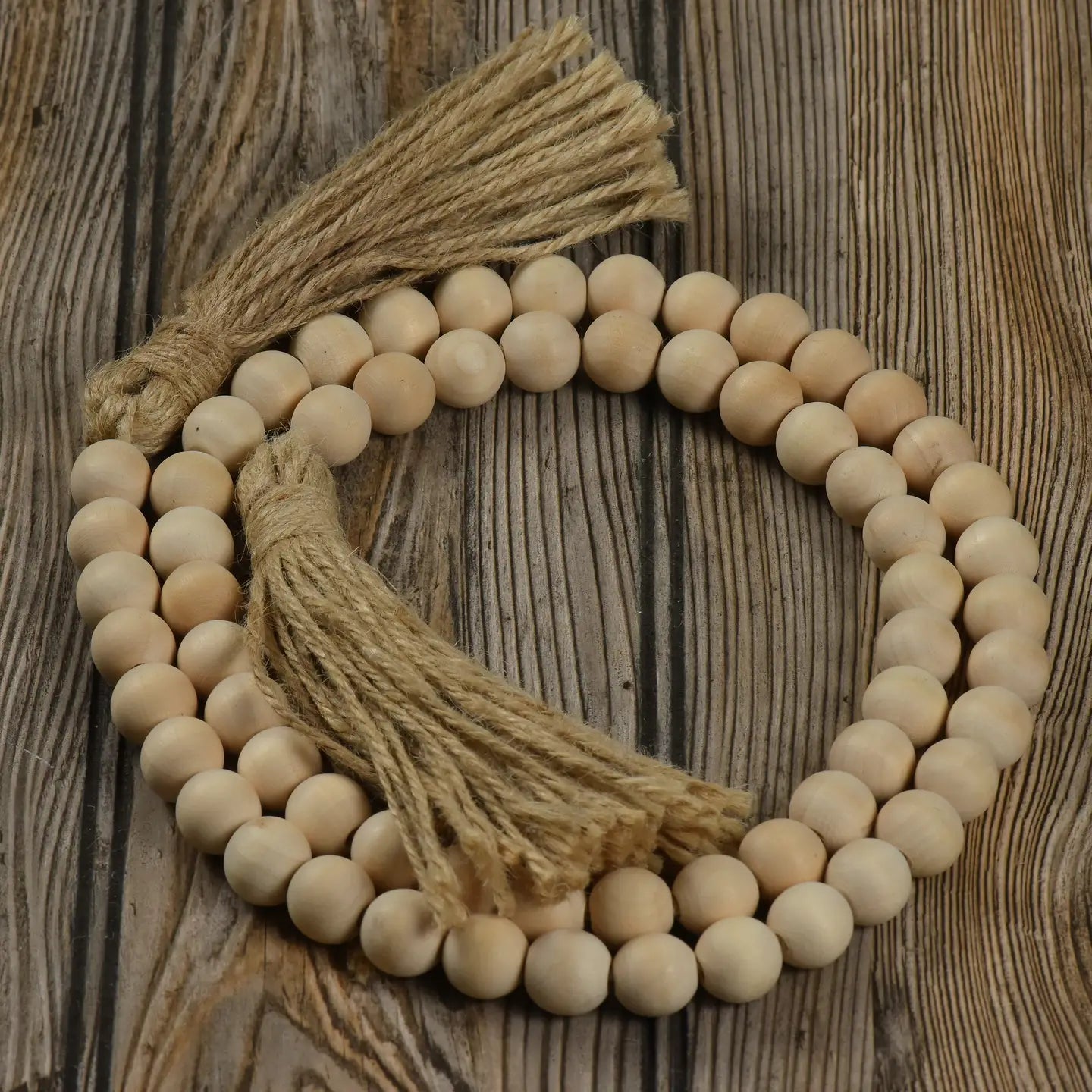 Natural wood bead garland with jute tassels. Great for a farmhouse accent to your decor.